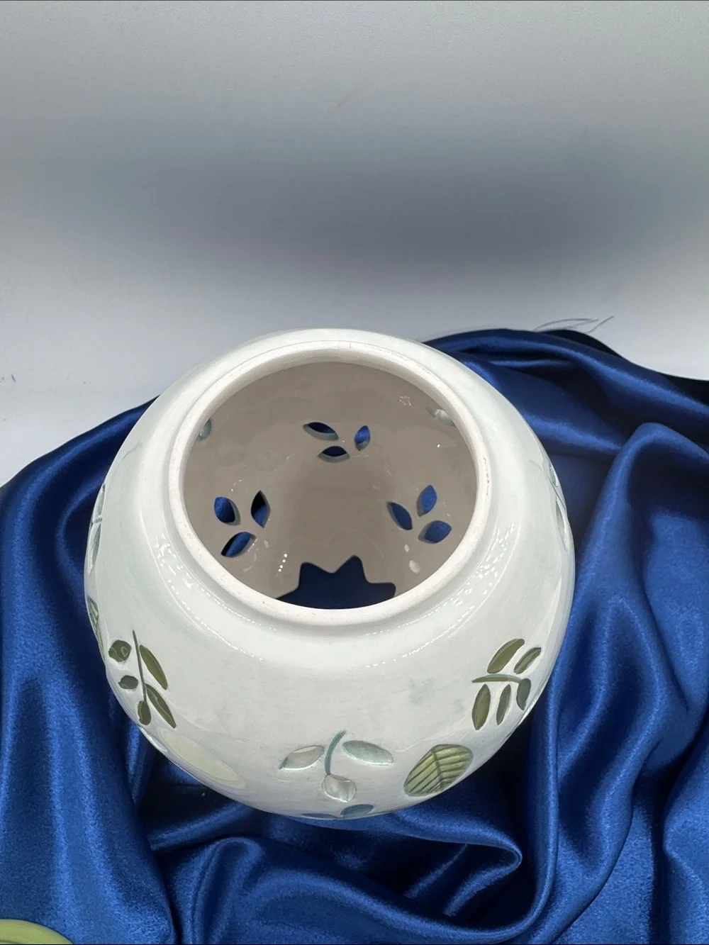 Ceramic illuminated globe/base featuring a pierced or cut-out floral design.